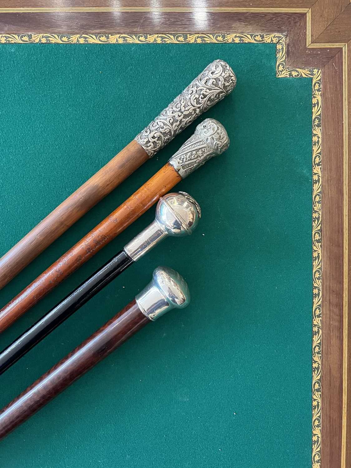 FOUR LATE 19TH / EARLY 20TH CENTURY WALKING CANES INCLUDING A VICTORIAN EXAMPLE WITH SILVER POMMEL