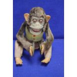 A VINTAGE BATTERY OPERATED SCARY LOOKING DANCING MONKEY