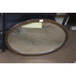 A FRAMED OVAL MIRROR