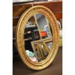 A LARGE OVAL GILT MIRROR 97 CM X 68 CM