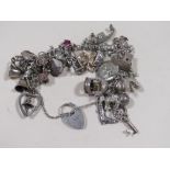A VINTAGE SILVER CHARM BRACELET AND CHARMS, APPROX 11g