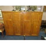 A LARGE OAK FOUR DOOR SCHOOL TYPE CUPBOARD H-136 W-194 CM NOTE -SPLITS IN TWO AND UNEVEN