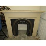 A MODERN CAST IRON FIRE SURROUND WITH A COMPOSITE SURROUND