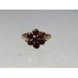 A HALLMARKED 9CT GOLD FLORAL CLUSTER DRESS RING, set with garnet type gemstones, ring size R,
