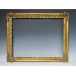 A LATE 18TH / EARLY 19TH CENTURY GOLD FRAME WITH CORNER EMBELLISHMENTS, leaf design to inner edge,