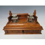 A SMALL DECORATIVE WOODEN DESK STAND WITH SINGLE DRAWER BELOW, complete with two fitted ink