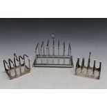 TWO SMALL HALLMARKED SILVER FOUR DIVISION TOAST RACKS, together with a larger silver plated six