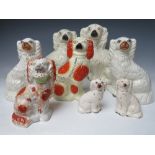 A COLLECTION OF EIGHT ASSORTED STAFFORDSHIRE SEATED SPANIELS, to include a large pair, H 30.5 cm (