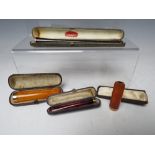 A COLLECTION OF FOUR GOLD BANDED CHEROOT / CIGARETTE HOLDERS, comprising two 375 examples, one