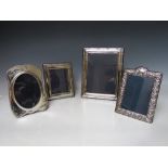 A COLLECTION OF FOUR HALLMARKED SILVER EASEL BACKED PHOTO FRAMES, varying sizes, dates