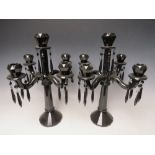 A PAIR OF VILLEROY AND BOCH MODERN DARK GLASS FIVE BRANCH CANDELABRA, faceted design with attached