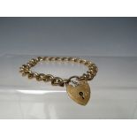 A HALLMARKED 9CT GOLD CHARM BRACELET, with hallmarked 9ct gold heart shaped clasp, approximately