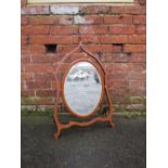 A LATE 19TH CENTURY MAHOGANY DRESSING MIRROR, the oval mirror supported on a shaped framed, H 76 cm