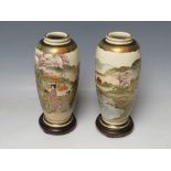 A PAIR OF JAPANESE VASES, decorated with typical scenes, with wooden stands and box, marks to