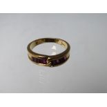 AN 18CT GOLD GEMSET RING, of simple crossover design with 8 baguette cut channel set ruby type