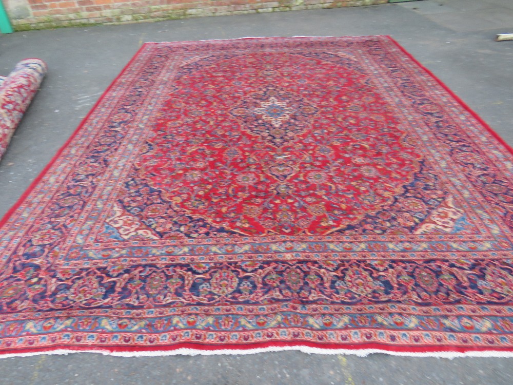 A LARGE RED / BLUE GROUND CARPET, APPROX 389 X 297 CM - WEAR THROUGHOUT - Image 7 of 8