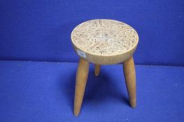 A MILKING TYPE STOOL WITH CELTIC DECORATION TO THE TOP