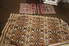 A PAIR OF VINTAGE EASTERN SADDLE BAGS AND A RUG