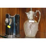 AN ANTIQUE SILVER PLATED CUT GLASS CLARET JUG TOGETHER WITH A LION MASK BOTTLE HOLDER (2)