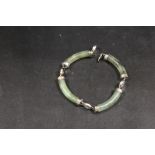 A MODERN FAUX JADE AND WHITE METAL BRACELET WITH ORIENTAL CHARACTER MARK EMBELLISHMENT