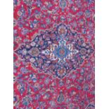 A LARGE RED / BLUE GROUND CARPET, APPROX 389 X 297 CM - WEAR THROUGHOUT