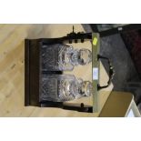 A TWO BOTTLE TANTALUS WITH MATCHED GLASS DECANTERS