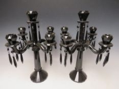 A PAIR OF VILLEROY AND BOCH MODERN DARK GLASS FIVE BRANCH CANDELABRA, faceted design with attached