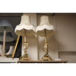 A PAIR OF ORNATE TABLE LAMPS WITH CREAM LAMP SHADES