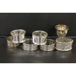SIX ASSORTED HALLMARKED SILVER NAPKIN RINGS TOGETHER WITH A HALLMARKED SILVER EGG CUP (7)