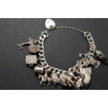 A CHARM BRACELET AND CHARMS WITH HALLMARKED SILVER HEART SHAPED CLASP