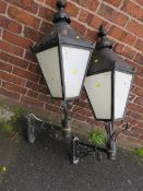 A PAIR OF LARGE EXTERNAL LANTERNS WITH COPPER TOPS, HAVING ORNATE CAST WALL BRACKETS