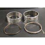 A FINE HALLMARKED SILVER HINGED BANGLE, TOGETHER WITH TWO LARGER UNMARKED WHITE METAL HINGED BANGLES