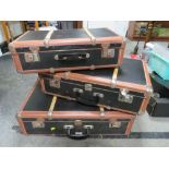 A SET OF THREE VINTAGE BANDED SUITCASES