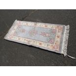 A SMALL CHINESE WOOLLEN RUG APPROX 138 X 61 CM