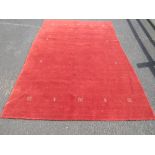 A LARGE MAINLY RED GROUND WOOLLEN CARPET APPROX 300 X 200 CM
