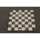 A MARBLE STYLE POLISHED STONE CHESS BOARD