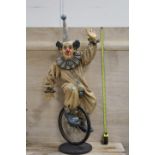 A LARGE RESIN MODEL OF A CLOWN ON A UNICYCLE