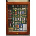 A DISPLAY CASE CONTAINING ROAB SASHES AND MEDALS RELATING TO RETFORD & DISTRICT 1992