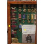 A DISPLAY CASE CONTAINING ROAB SASHES AND MEDALS RELATING TO RETFORD & DISTRICT 1993