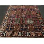 A LARGE BROWN GROUND PATTERNED WOOLLEN CARPET APPROX 312 X 205 CM