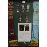 A DISPLAY CASE CONTAINING ROAB SASHES AND MEDALS RELATING TO RETFORD & DISTRICT 2012 AND
