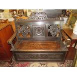 AN EARLY 20TH CENTURY CARVED OAK SETTLE WITH LIFT-UP SEAT, W 117 cm