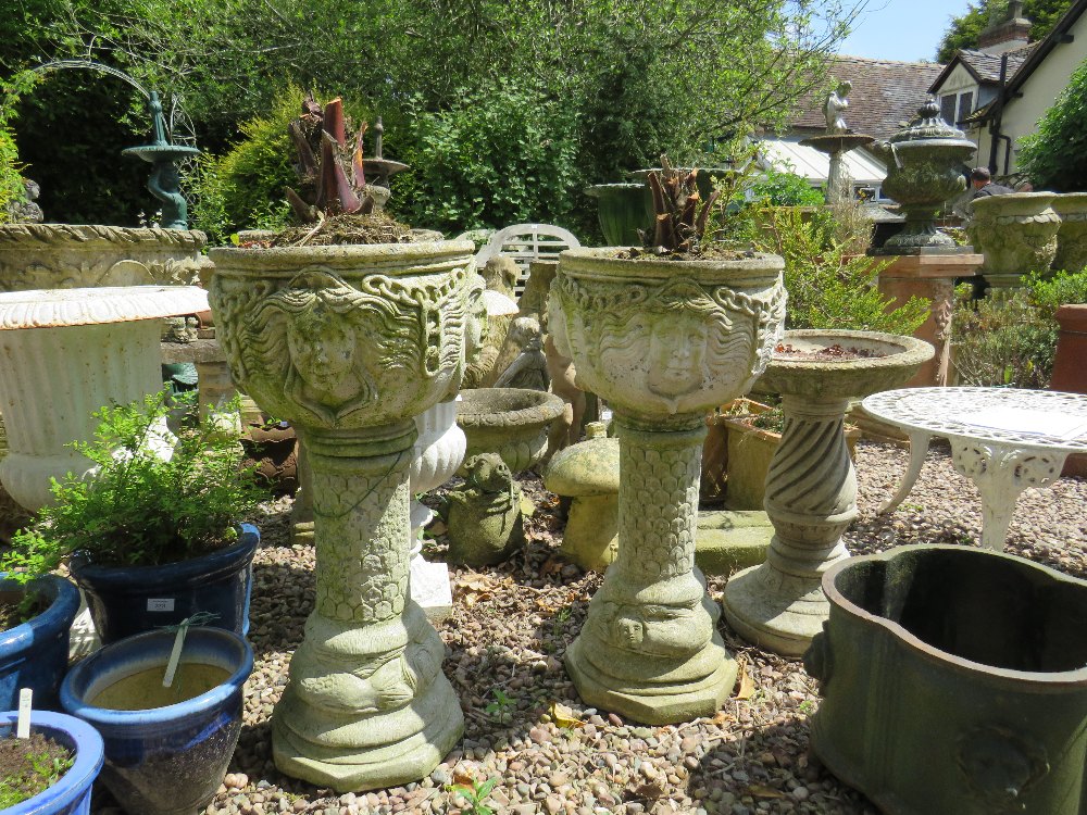 A PAIR OF STONE MASK HEAD URNS ON STANDS, H 78 cm (2)