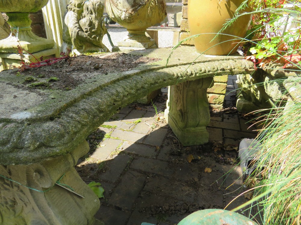 A LARGE CURVED GARDEN STONE BENCH