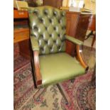 A 20TH CENTURY GREEN LEATHER SWIVEL OFFICE ARMCHAIR WITH BUTTON BACK DETAIL