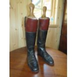 A TRADITIONAL TAN AND BLACK LEATHER PAIR OF HUNTING BOOTS WITH WOODEN TREES