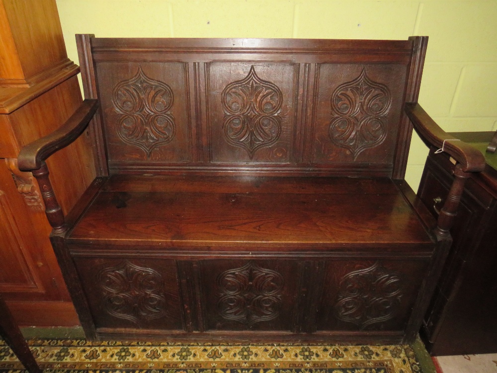 AN ANTIQUE CARVED OAK MONKS BENCH WITH LIFT-UP SEAT,W 125 cm