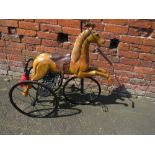 A NOVELTY REARING HORSE ON A CAST TRICYCLE BASE