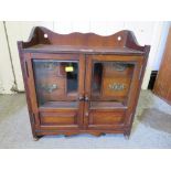 A VINTAGE WOODEN SMOKERS CABINET WITH GLAZED DOORS