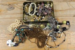 A SMALL TIN OF ASSORTED COSTUME JEWELLERY